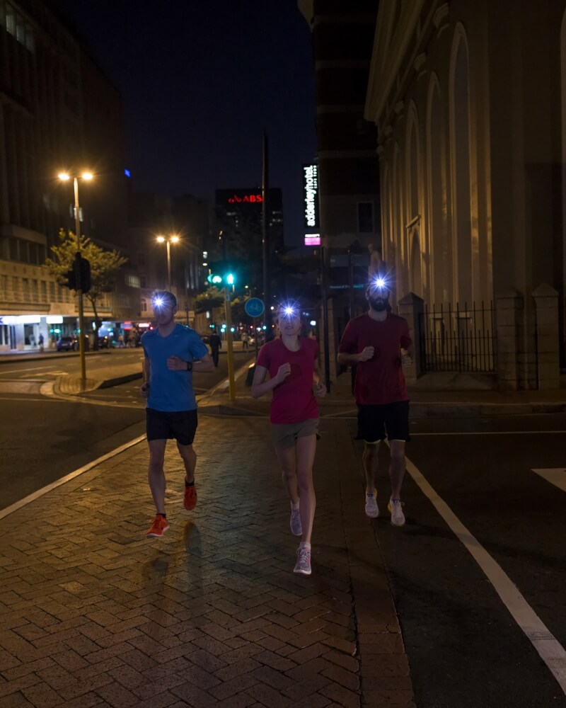 Trhee runners in the city by night