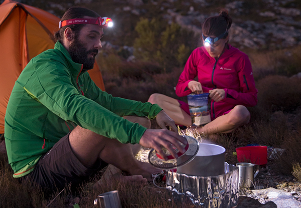 Two campers using headlamps
