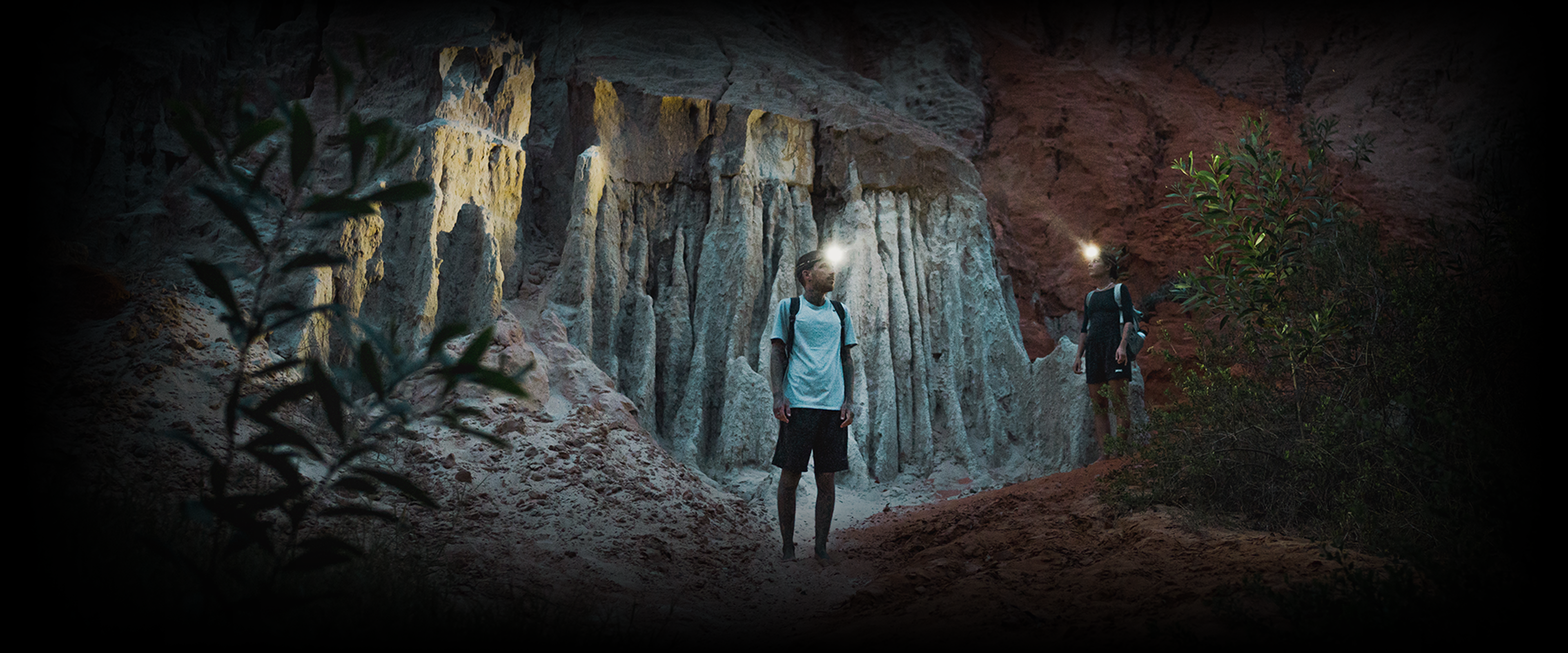 A man in a cave with a headlamp