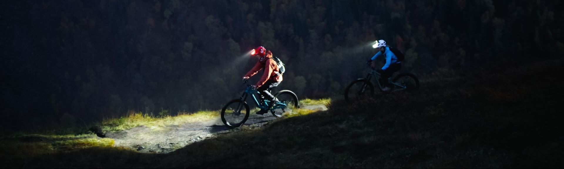 Das Bild zeigt Radfahrer mit Stirnlampen im Gelände