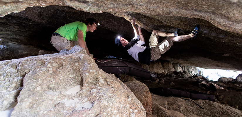 Two peaple climbing with headlamps