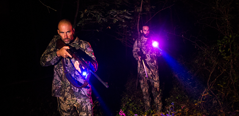 Two hunters with flashlights