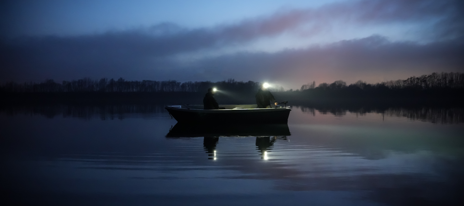 Two people on a boat with headlamps