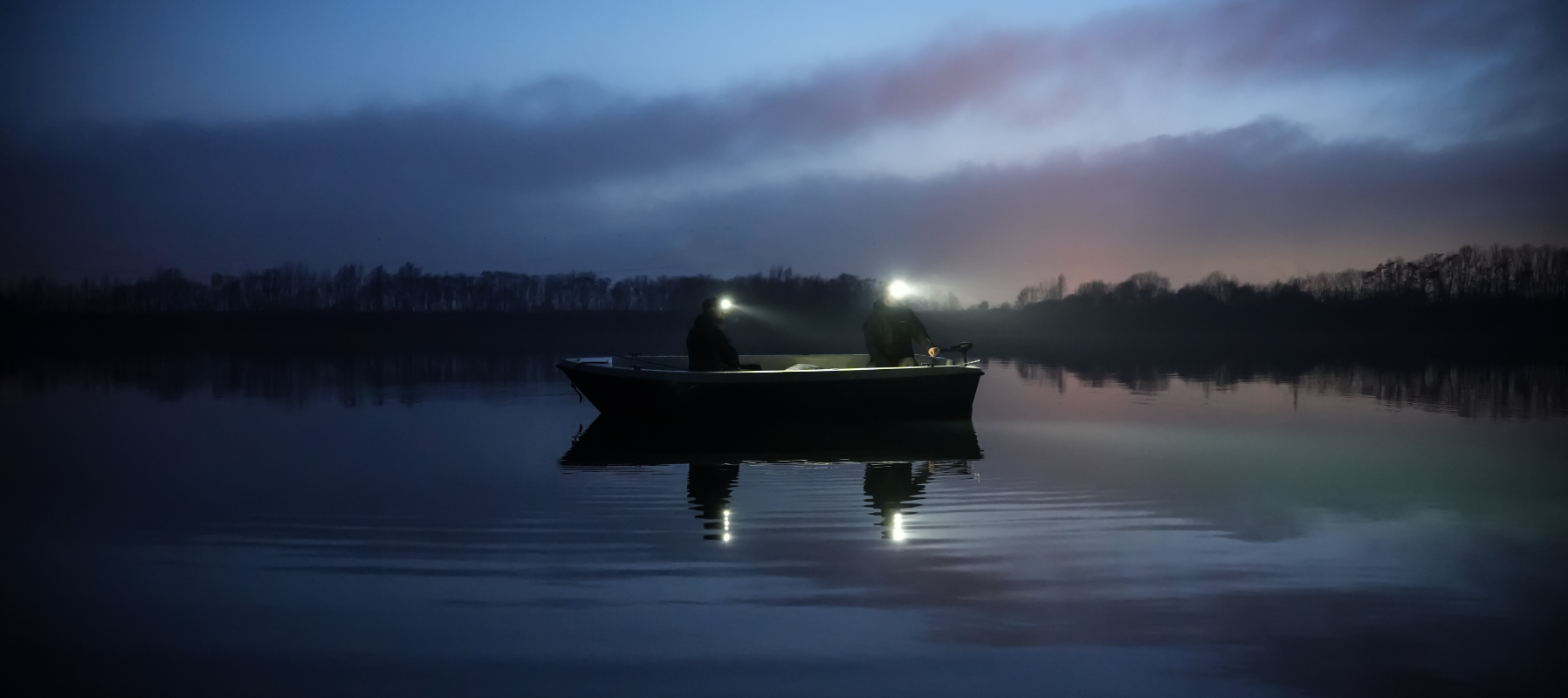 Zwei Menschen in einem Boot mit Stirnlampen