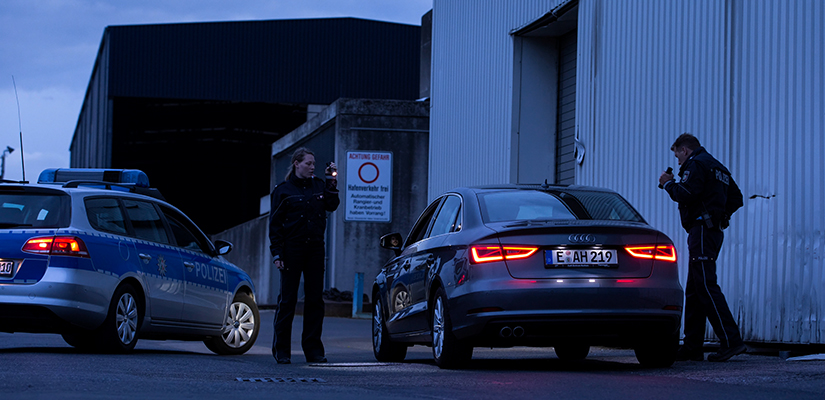 A a police woman and a police man with a flashlight