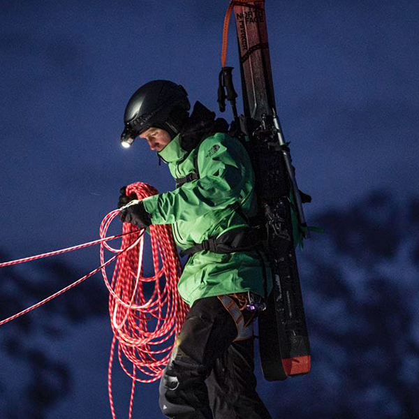 Das Bild zeigt einen Mann mit Outdoor-Stirnlampe, die an einem Helm befestigt ist