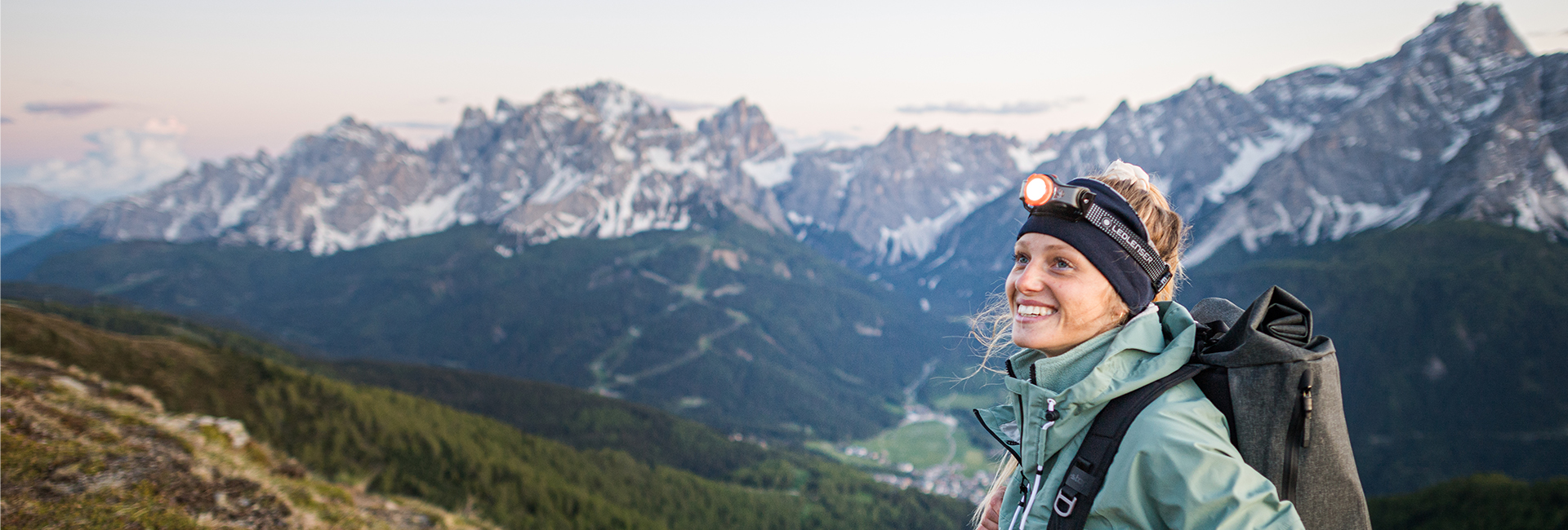 Das Bild zeigt eine Frau mit Stirnlampe in den Bergen.