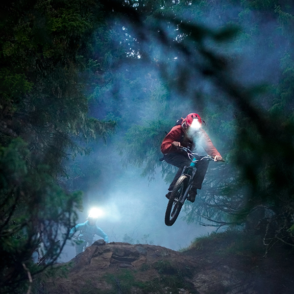 Das Bild zeigt einen Mountainbiker mit Outdoor-Stirnlampe