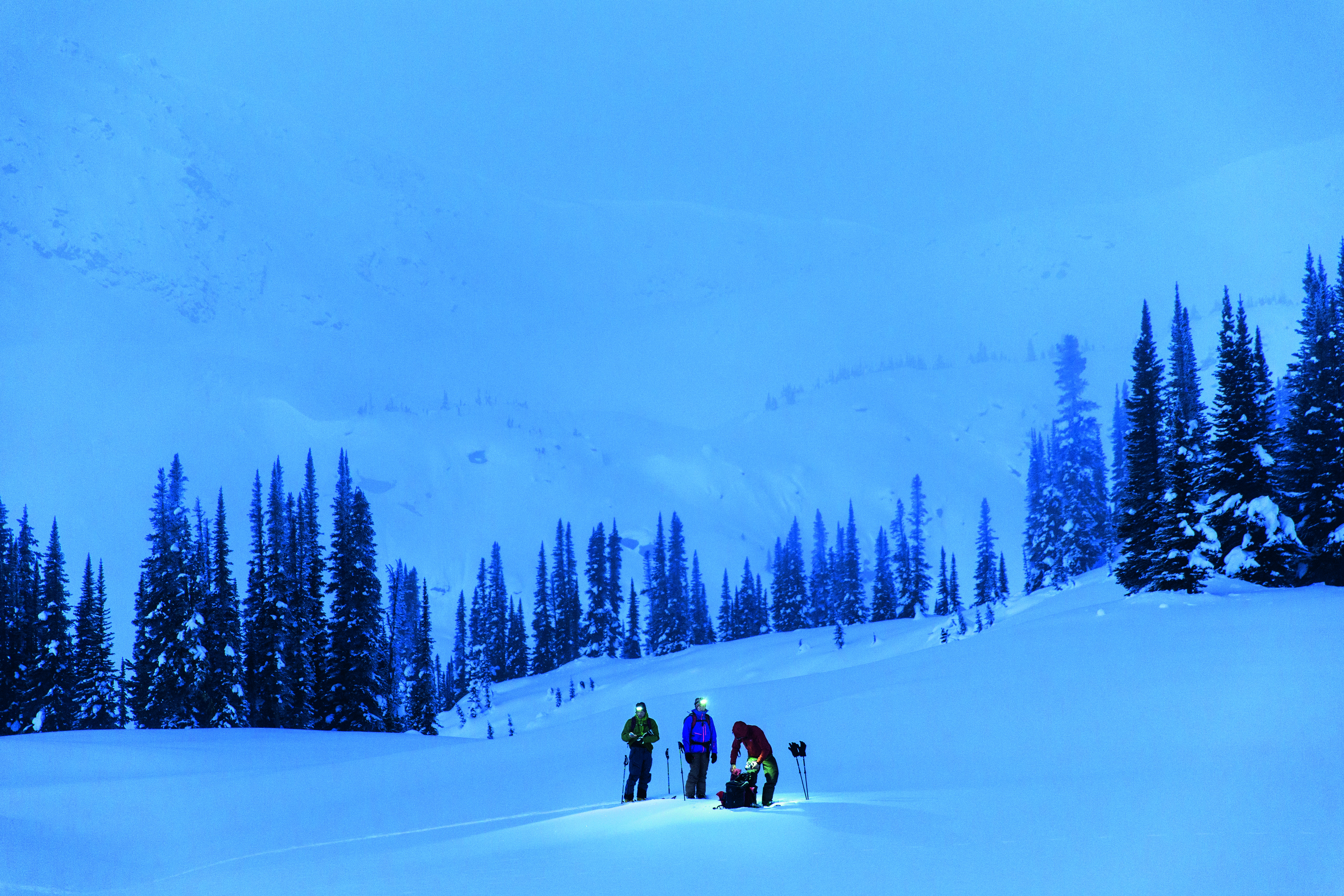 People in the snow using headlamps