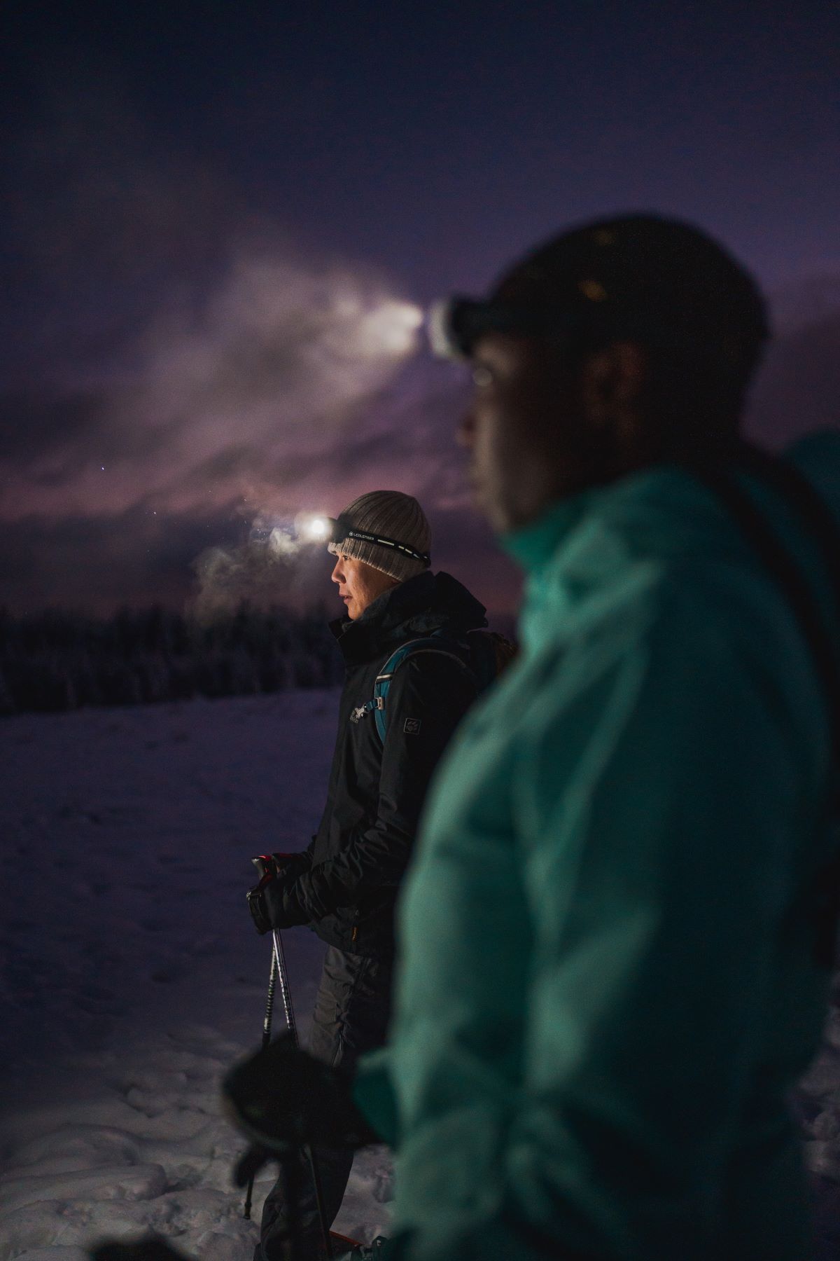 Das Bild zeigt zwei Skifahrer mit Stirnlampen