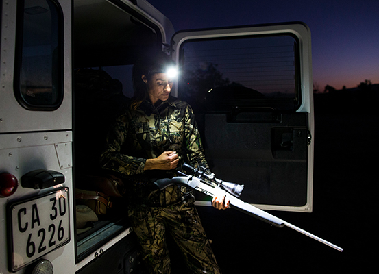 Jägerin mit Waffe und Stirnlampe